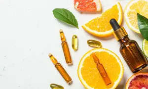 Kapsułki z witaminą E (tocopheryl acetate) i cytrusy, symbol odżywienia i naturalnej pielęgnacji.