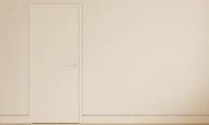 Puerta blanca minimalista con manija discreta y un rodapié enrasado que se funde con la pared, creando un espacio limpio y moderno.