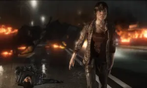 Jodie Holmes stoi na tle płonących samochodów, obok leży nieprzytomny żołnierz. To scena z gry Beyond Two Souls, która pokazuje intensywny czas gry.