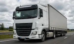 Camion blanc sur l'autoroute, le conducteur anticipe le freinage.