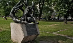 Pomnik psa Dżoka, wiernego towarzysza, siedzi w dłoniach, symbolizując oddanie i miłość.