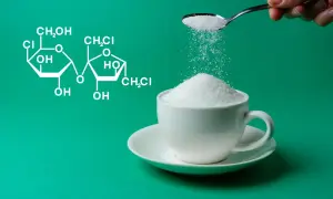 Struktura chemiczna sukralozy obok filiżanki cukru. Dowiedz się, sukraloza co to jest i jak działa.