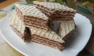 Kawałki wafli z kremem czekoladowym, przypominające smakiem wafle z mlekiem w proszku, ułożone na białym talerzu.