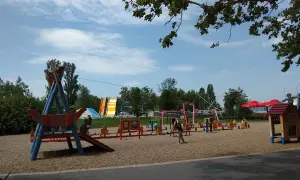 Plac zabaw z atrakcjami dla dzieci nad Balatonem: zjeżdżalnie, huśtawki i domek.