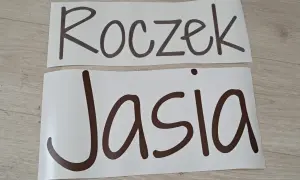 Napis "Roczek Jasia" na białych arkuszach, gotowy do dekoracji przyjęcia.