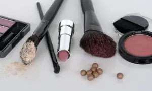 Zestaw do makijażu krok po kroku: puder, szminka, róże i pędzle.