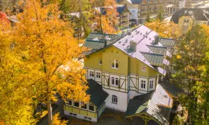Jesienny hotel w Szklarskiej Porębie otoczony złotymi drzewami. Widok z góry na architekturę górską.