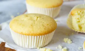 Zarte Muffins, perfekt für das Muffins Grundrezept. Einer ist angeschnitten und zeigt die fluffige Textur.