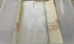 Przezroczyste etui na telefon zasypane sodą oczyszczoną, przygotowane do czyszczenia. To prosty sposób, jak wyczyścić zżółknięte etui.