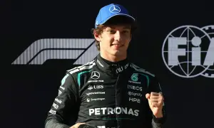 George Russell, piloto de Fórmula 1, celebra con un puño cerrado. Las noticias de Fórmula 1 lo muestran con el logo de Mercedes y FIA.