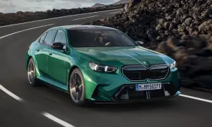 Zielone m5 bmw pędzi po krętej drodze wśród skalistych krajobrazów.