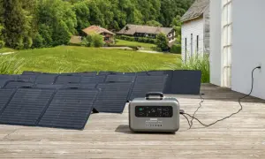 Instalación de baterías solares en un porche de madera, con paneles solares desplegados y una unidad de energía portátil conectada a una casa.