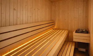 En varm och inbjudande bastu med träbänkar och diskret belysning. Perfekt bastu inspiration för avkoppling.