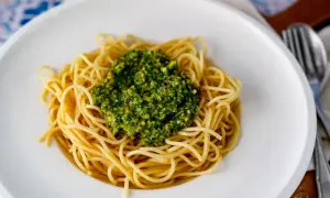 Spaghetti mit einem Berg von leckerem Pistazien Pesto, garniert mit gehackten Pistazien.