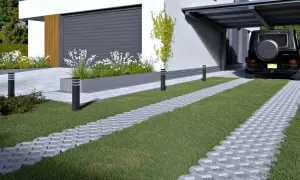 Nowoczesne aranżacje kostka brukowa wzory: ścieżki z ażurowej kostki brukowej i płyt betonowych tworzą estetyczny podjazd do domu z garażem.