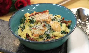 En härlig kycklingpasta med soltorkade tomater och spenat, perfekt för ett snabbt och gott kycklingpasta recept. Serveras i en vacker blå skål.