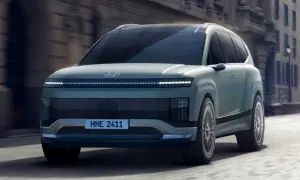 Przyszłościowy Hyundai Ioniq 9 w kolorze miętowym przemierza miejskie ulice, prezentując swój unikalny design i innowacyjne oświetlenie.