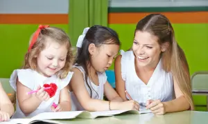 Lehrerin hilft Kindern beim Malen. Ein schönes lerngeschichte beispiel, wie Kinder kreativ werden.