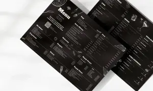 Menu z czarnym tłem, prezentujące ofertę a la carte. Widoczne sekcje: Zupy, Dania Główne, Pizza, Makaron, Burgery, Desery, Napoje Gorące i Zimne, Piwo, Drink, Wina.