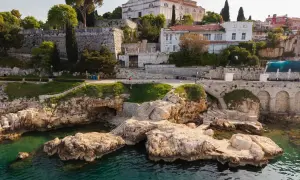 Felsige Küste mit kristallklarem Wasser und einer Kirche auf dem Hügel. Entdecke Rovinj Geheimtipps abseits der Touristenpfade.