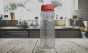 Przezroczysta butelka z czerwonym wieczkiem na drewnianym blacie. Dowiedz się, jak usunąć zapach z plastikowej butelki, by znów była świeża.