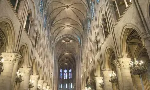Das Innere der Notre Dame erstreckt sich mit seinen gotischen Bögen und Gewölben in die Höhe. Buntglasfenster erhellen den Raum.