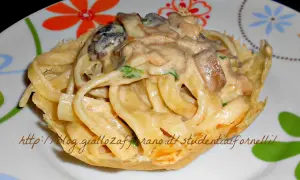 Scialatielli ai funghi cremosi serviti in un cestino croccante, un piatto invitante e saporito.