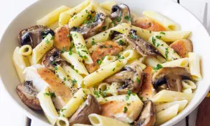 Penne z kurczakiem i pieczarkami, posypane natką pietruszki i pieprzem. Pyszne danie, które z pewnością zadowoli każdego miłośnika makaronu z kurczakiem.