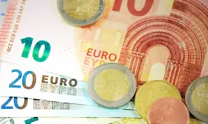 Euro banknoty o nominałach 10 i 20 oraz monety. Obrazek symbolizuje wskaźnik ogólnego zadłużenia.