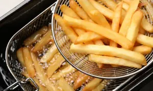 Złociste, chrupiące frytki mcdonald w koszyku do smażenia.