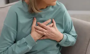 Kobieta trzymająca się za serce. Badanie poziomu lipoproteiny jest kluczowe dla oceny ryzyka chorób serca.