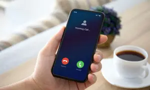 Dłoń trzyma smartfon Samsung z ekranem przychodzącego połączenia. Możliwe przekierowanie połączeń.