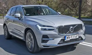 Srebrny Volvo XC60 2026 jedzie po drodze, za kierownicą mężczyzna.