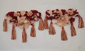 Dos adornos florales con borlas rojas y doradas, perfectos para saber como hacer hombreras flamencas.