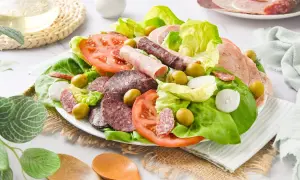 Amanida catalana con lechuga, tomate, aceitunas, cebolla y embutidos variados.