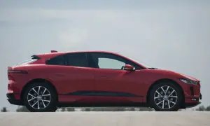 Czerwony Jaguar I-PACE na tle błękitnego nieba. Elegancki, elektryczny SUV gotowy do dynamicznej jazdy.