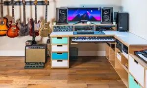 A musician's dream setup for computer music creation, featuring guitars, keyboards, speakers, and a powerful computer.