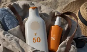 Borsa da spiaggia con crema solare SPF 50 e 30, cappello di paglia e occhiali da sole. La crema solare 50 protegge a lungo.