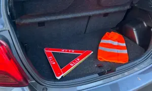 Triangle de signalisation et gilet de haute visibilité dans un coffre de voiture, prêts pour la signalisation dépassement chargement arrière.