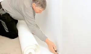 Man skär tapet för renovering. Noggrant arbete med renoveringstapet skarvar för ett perfekt resultat.