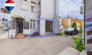 Budynek z wejściem do biura ubezpieczeń i oknem, zaznaczony niebieską ramką.
