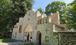 Kamienny, zabytkowy wjazd do Puszczy Dulowskiej z figurą świętego i krzyżami.