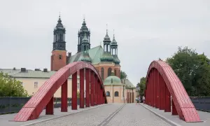 Czerwony most na Ostrowie Tumskim w Poznaniu, idealny na spacer i odkrywanie poznańskich atrakcji dla dorosłych. W tle katedra.
