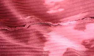Różowa, prążkowana dzianina z efektem tie-dye. Elastyczna przędza do produkcji dzianin, widoczne szwy.