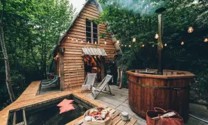 Une cabane dans les arbres dans les Landes, avec un bain nordique fumant et un hamac invitant. Parfait pour une escapade nature.