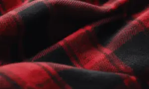 Rotes und schwarzes Karomuster auf weichem Stoff. Das ist typisch für Flanell, das sich warm und gemütlich anfühlt.