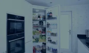 Otwarta lodówka pełna jedzenia, ale niestety lodówka nie chłodzi. Widać napoje, owoce, warzywa i inne produkty spożywcze.