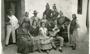 Grupo de gitanos en Granada, con un hombre tocando la guitarra. Captura la esencia del significado del flamenco.