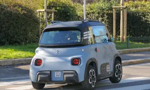 Citroën Ami in prova su strada, vista posteriore. Un veicolo elettrico compatto e originale, ideale per la mobilità urbana.
