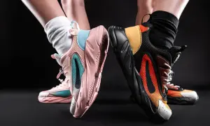 Dwie pary kolorowych sneakersów, idealne jako jakie buty na wf do szkoły. Różowe z błękitem i czarne z pomarańczem.